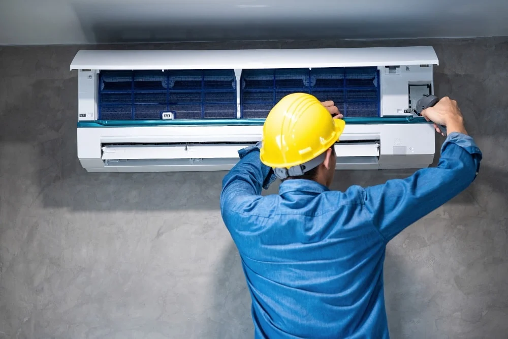 Technician servicing a wall-mounted air conditioner